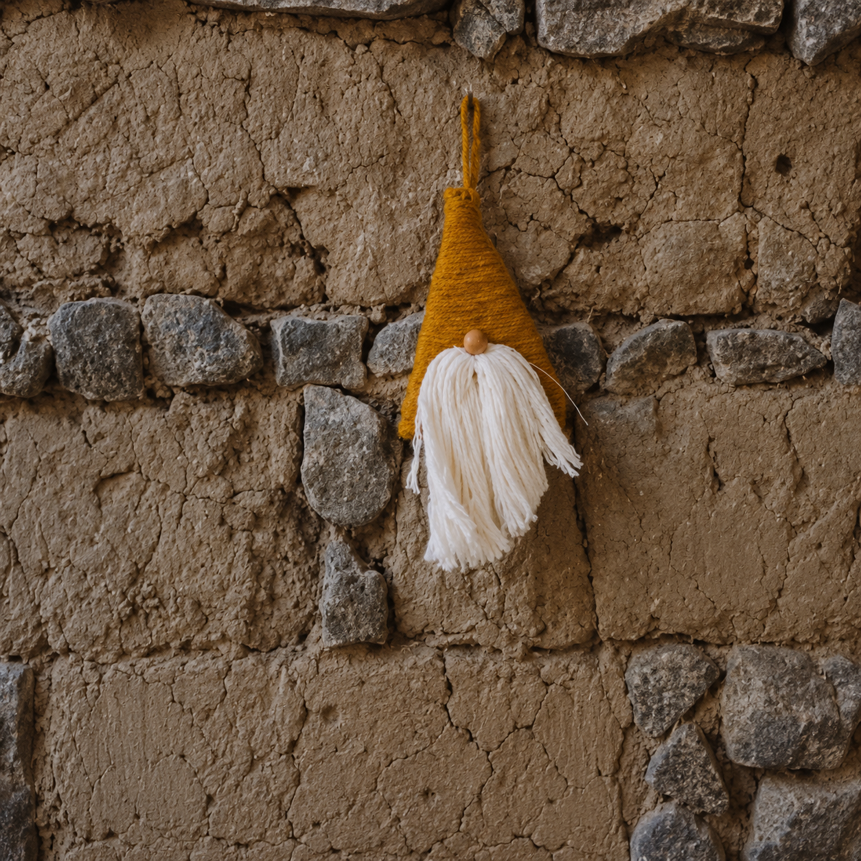 Adorno artesanal de lana colgado sobre muro de adobe y piedra en escuela Waldorf Cholula