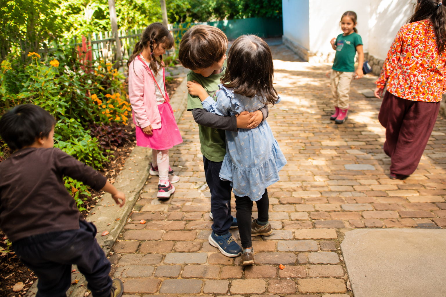 Niños abrazándose y jugando en un camino de piedra en una escuela Waldorf en Cholula