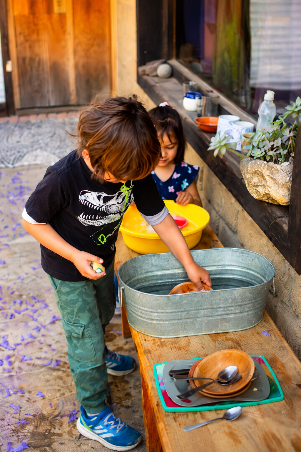 Niños jugando con agua y recipientes en un patio de Tlaollin, escuela Waldorf Cholula