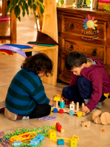 Niños jugando con juguetes de madera en un salón de Tlaollin, escuela Waldorf Cholula