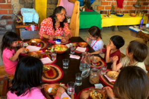 Niños compartiendo alimentos en una mesa comunitaria de Tlaollin, escuela Waldorf Cholula